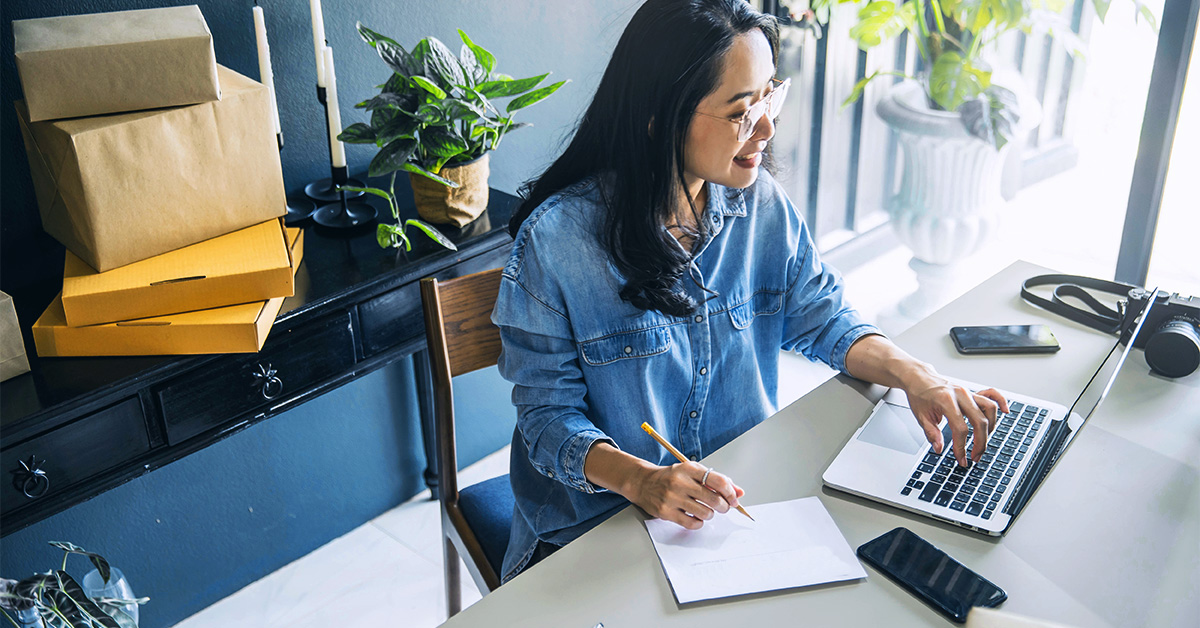 Mulher em frente a um notebook pesquisa como vender pela internet