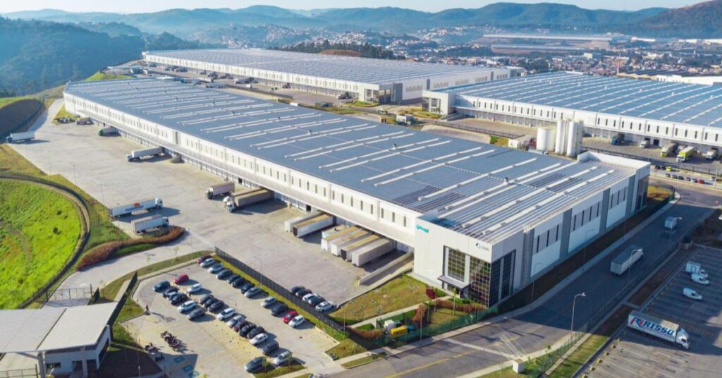 A imagem mostra o maior corssdocking da Logg: Cajamar II, visto de cima. Um espaço que tem capacidade de processar até 1 bilhão de pacotes por dia. É por meio dos crossdockings que a Loggi se destaca no setor de envio de encomendas. 