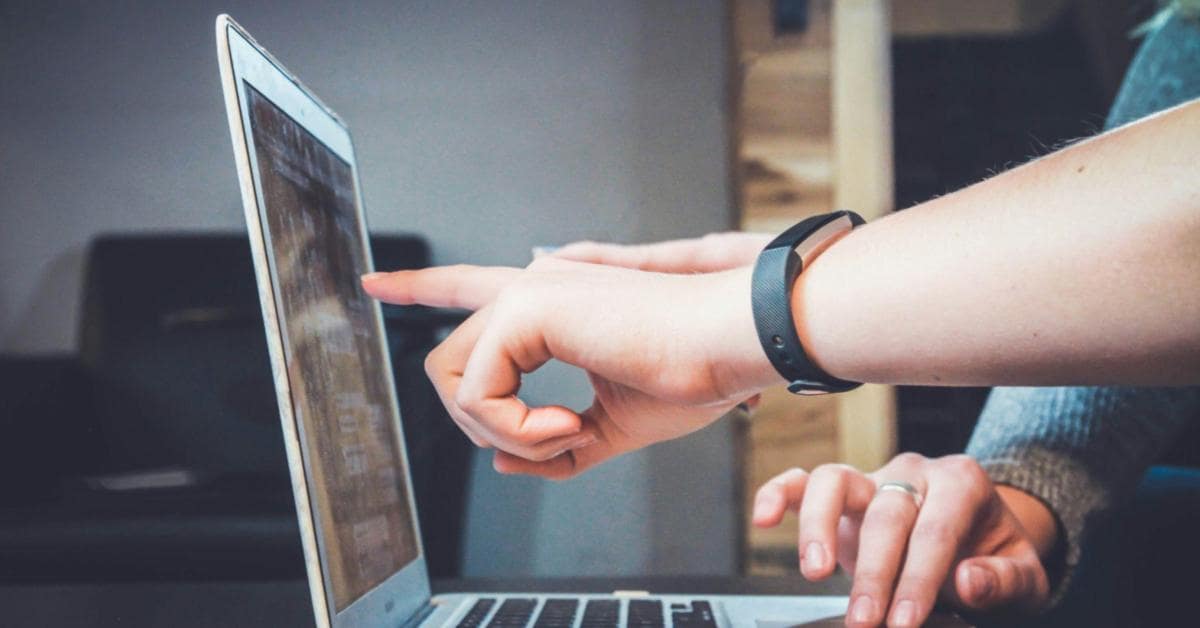 Mãos apontando para um notebook indicando como encontrar fornecedores dropshipping
